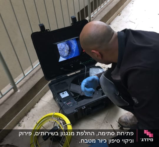 אדם עם כפפות כחולות משתמש במצלמת ביוב